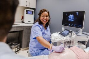Sonographer performing ultrasound on pregnant patient