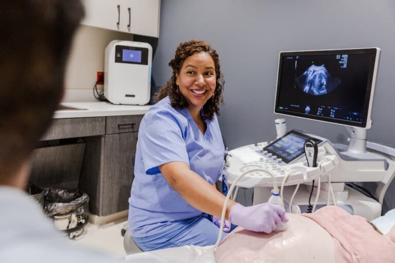 Sonographer performing ultrasound on pregnant patient