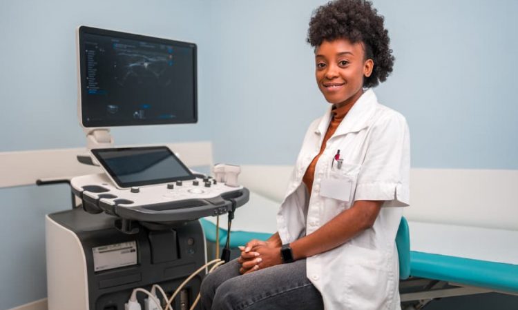 ultrasound technician sitting in front of machine